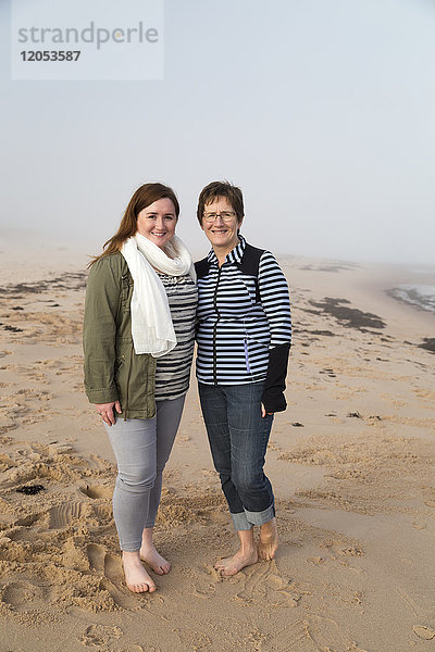 Porträt einer Mutter und ihrer Tochter  die barfuß an einem Strand im Nebel stehen; Prince Edward Island  Kanada