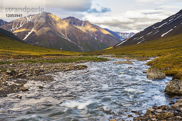 Ein klarer Strom fließt über die Tundra unterhalb der Berge der Brooks Range; Alaska  Vereinigte Staaten von Amerika