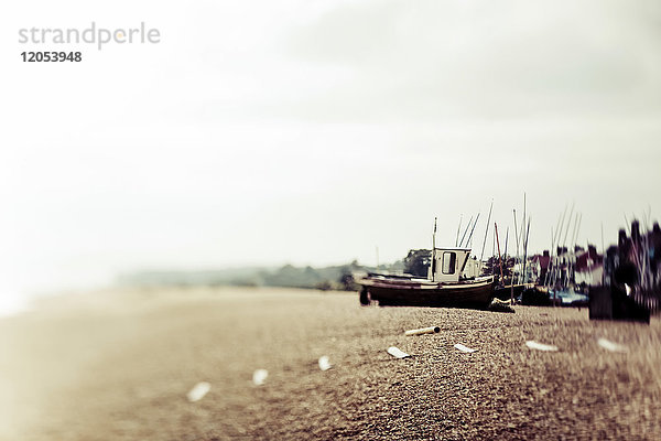 Ein traditionelles Fischerboot am Ufer mit Nebel entlang der Küste; England