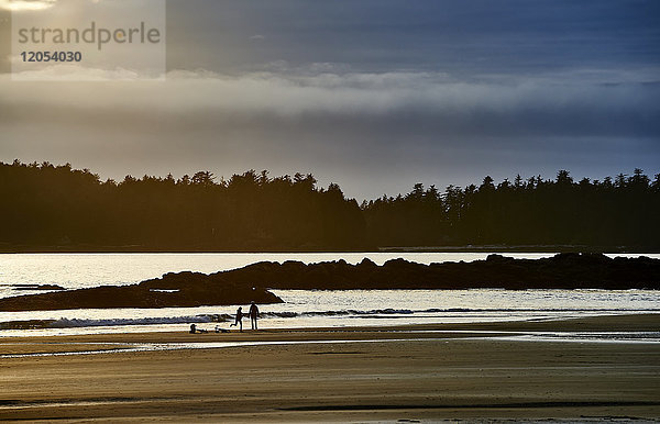 Silhouette eines Paares und ihrer Fahrräder am Mackenzie Beach bei Sonnenuntergang; Tofino  British Columbia  Kanada