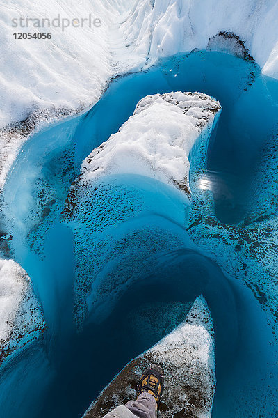 Der Stiefel eines Wanderers zeigt den Blick auf das tiefe  blaue Schmelzwasser eines Gletschers im Wrangell-St. Elias National Park; Alaska  Vereinigte Staaten von Amerika