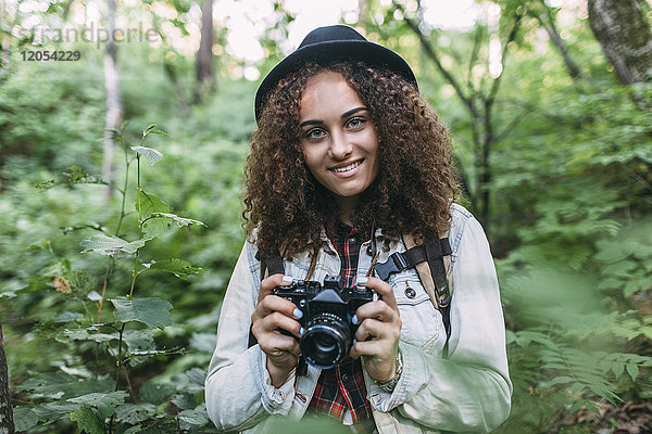 Porträt eines lächelnden Teenagermädchens beim Fotografieren in der Natur