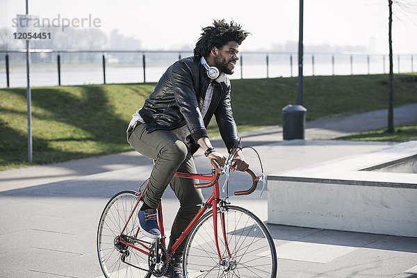 Lächelnder Mann auf dem Fahrrad am Flussufer