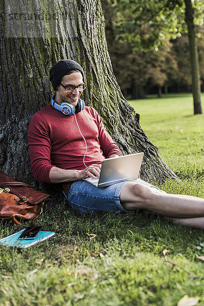 Mann mit Laptop im Park