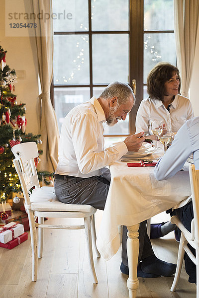Senior mit Familie am Weihnachtstisch essen