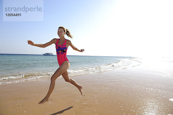 Ägypten  Soma Bay  glückliche Frau  die am Strand rennt