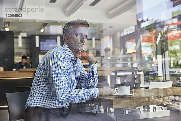 Geschäftsmann wartet im Coffee-Shop am Flughafen