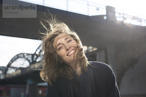 Porträt einer glücklichen Frau mit blasenden Haaren