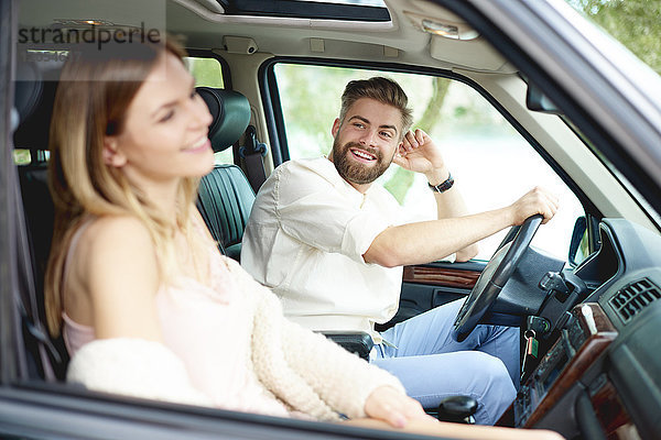 Glückliches junges Paar im Auto
