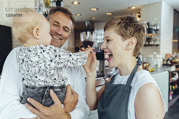 Kellnerin spielt mit Baby des Kunden im Cafe