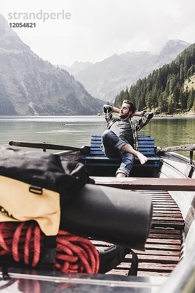 Österreich  Tirol  Alpen  entspannter Mann im Boot auf dem Bergsee