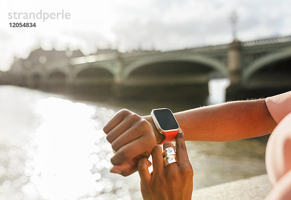 UK  London  Nahaufnahme der Frau mit ihrer Smartwatch bei der Westminster Bridge