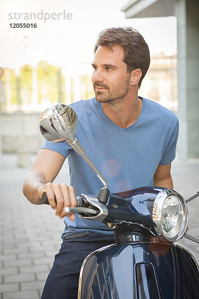 Mann auf einem Motorroller sitzend