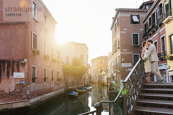 Italien  Venedig  küssendes Brautpaar bei Sonnenaufgang auf der Treppe stehend