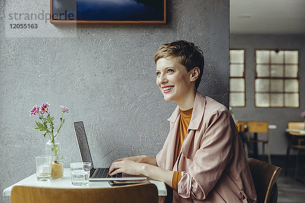 Frau arbeitet im Cafe mit ihrem Laptop
