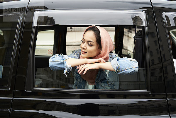 UK  England  London  junge Frau in Hijab mit Blick aus dem Taxi