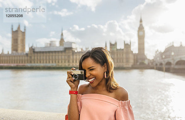 UK  London  schöne Frau beim Fotografieren nahe der Westminster Bridge