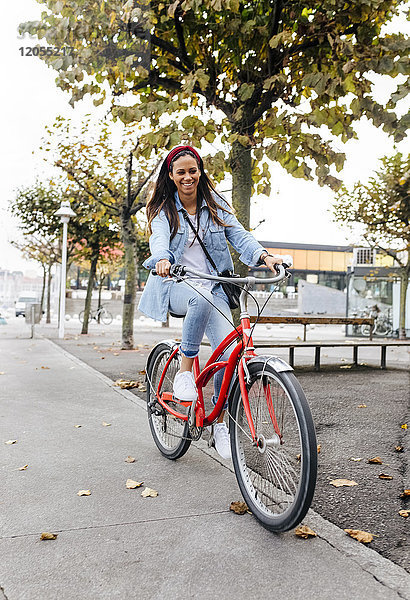 Spanien  Gijon  junge Frau beim Radfahren in der Stadt