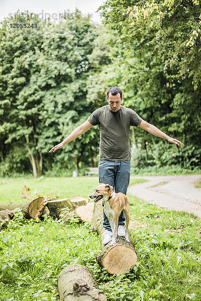 Mann mit Hund beim Balancieren im Park