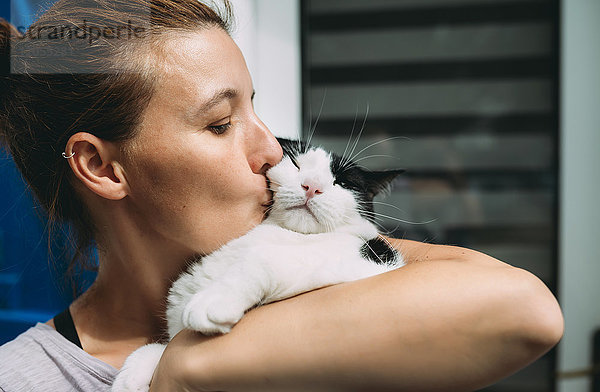 Frau hält und küsst ihre Katze