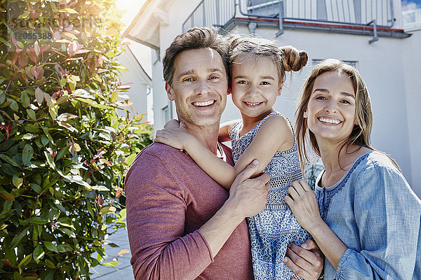 Porträt einer glücklichen Familie vor ihrem Haus