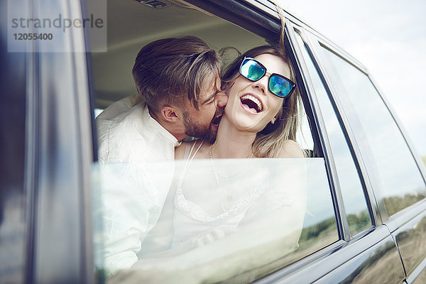 Verspieltes  liebevolles junges Paar im Auto
