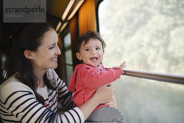 Glückliche Mutter und kleines Mädchen reisen mit dem Zug