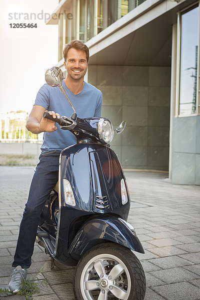 Mann auf einem Motorroller sitzend