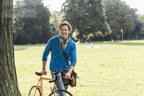 Porträt eines entspannten Mannes mit Rennrad im Park
