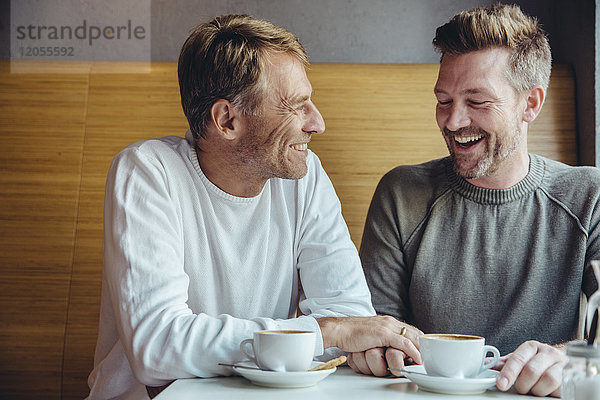 Schwules Paar genießt die gemeinsame Zeit im Cafe
