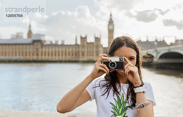 UK  London  schöne Frau beim Fotografieren nahe der Westminster Bridge