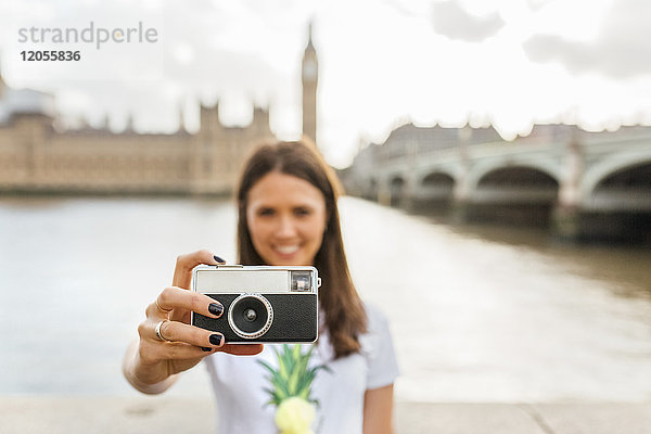 UK  London  Frau mit altmodischer Kamera an der Westminster Bridge