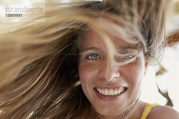 Porträt einer lachenden jungen Frau mit wehendem Haar