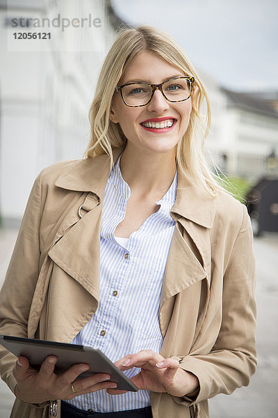 Porträt einer lächelnden jungen Geschäftsfrau mit Tablette