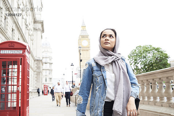 UK  England  London  junge Frau mit Hijab  die in der Stadt spazieren geht