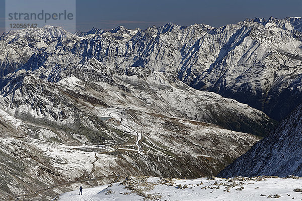 Österreich  Tirol  Ötztal  Sölden  Frau in schneebedeckter Landschaft mit Blick auf die Ötztaler Gletscherstraße
