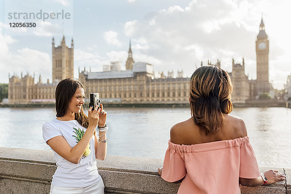 UK  London  Frau mit Freundin bei Palace of Westminster fotografiert