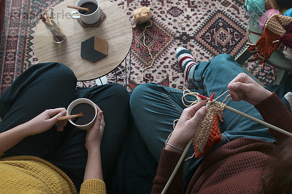 Junges Paar beim Stricken und Kaffeetrinken im Wohnzimmer  Draufsicht