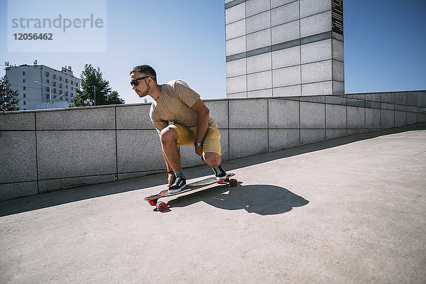 Junger Mann auf dem Skateboard in der Stadt