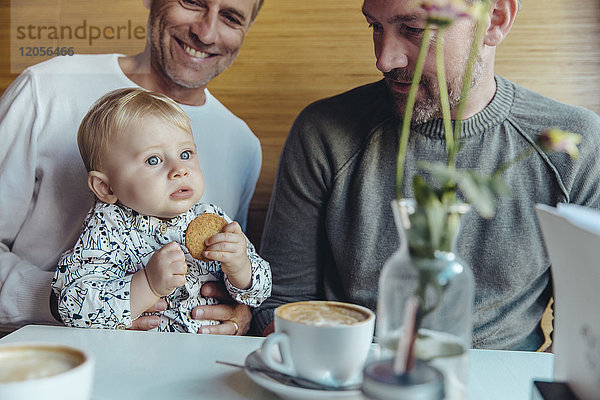 Schwules Paar sieht ihr Baby im Cafe an