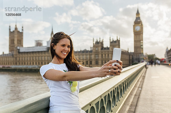 UK  London  schöne Frau  die einen Selfie auf der Westminster Bridge nimmt.