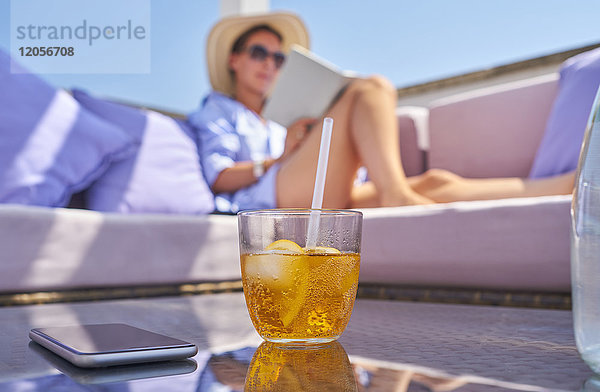 Glas Crodino  Smartphone und Frau entspannen auf dem Sonnendeck im Hintergrund
