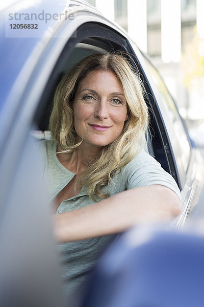 Porträt einer lächelnden Frau im Auto