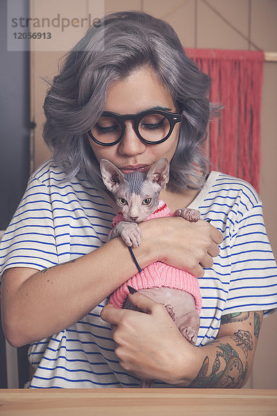 Junge Frau mit Sphynx-Katze im Pullover