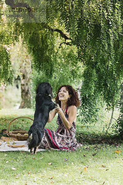 Frau mit Hund beim Picknick im Park