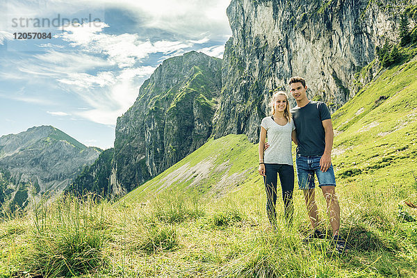 Deutschland  Bayern  Pfronten  Portrait eines jungen Paares auf der Alm bei Aggenstein