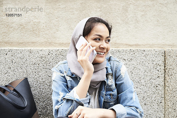 Junge Frau mit Hijab am Handy