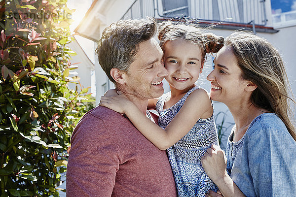 Porträt einer glücklichen Familie vor ihrem Haus