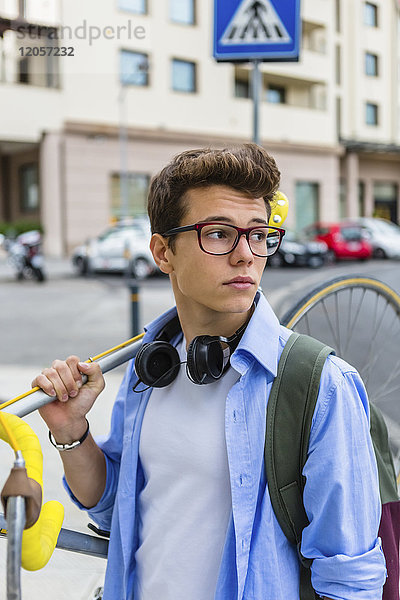 Porträt eines jungen Mannes mit Rennrad auf der Schulter
