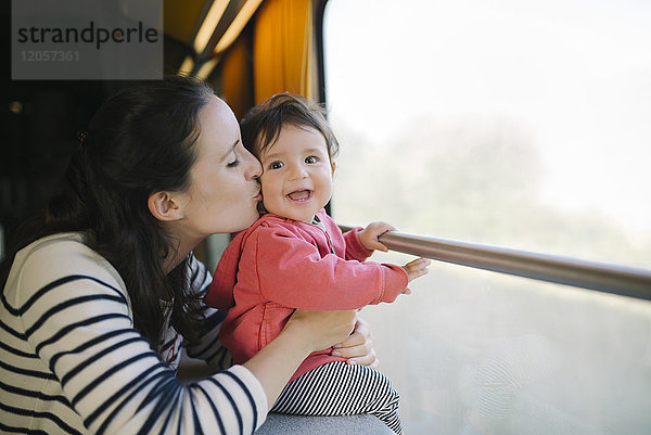 Glückliche Mutter und kleines Mädchen reisen mit dem Zug